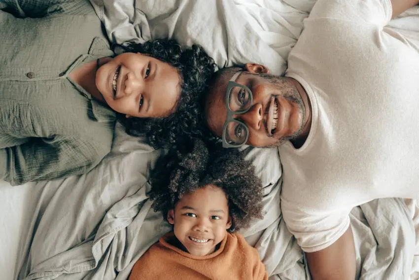 a man and two children lying in bed