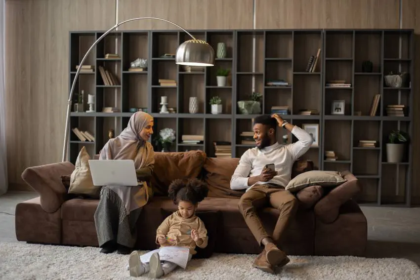 a woman, a man, and a child spending time together in a living room